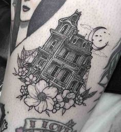 a woman's thigh with an old house tattoo on it