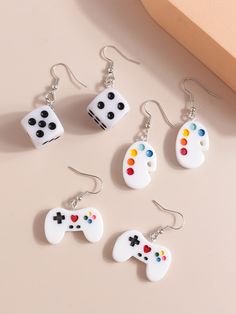 four pairs of earrings with dices on them, one is white and the other is black