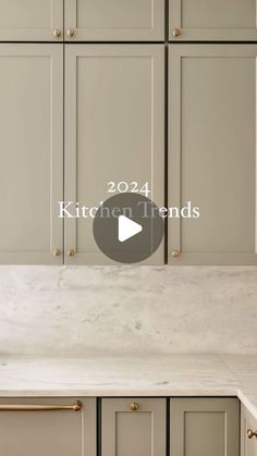 a kitchen with gray cabinets and white counter tops, the words kitchen trends written in gold