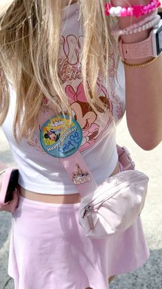 a girl in a pink skirt holding a cell phone