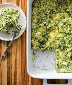 a casserole dish with spinach and cheese in it on a wooden table