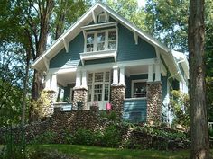 a small blue and white house in the woods