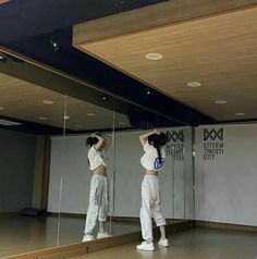 two women standing in front of mirrors doing exercises