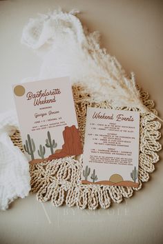 the wedding stationery is laid out on top of a doily with a white blanket