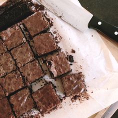 some brownies sitting on top of a cutting board next to a knife