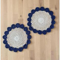 two blue and white crocheted doilys on wood floor next to each other