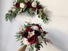 two brides bouquets with red and white flowers on the top, one being held by their hands