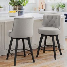 two gray bar stools sitting on top of a kitchen counter