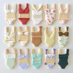 decorated cookies in the shape of bathing suits and bras are arranged on a white surface