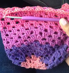 a crocheted purse with a pink pen sticking out of the front and side