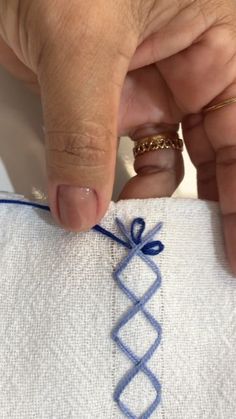 someone is stitching something on a piece of cloth