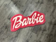 a red and white patch with the word barbie on it