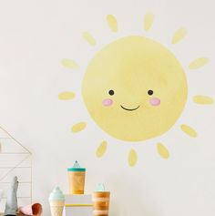 a wall with a sun painted on it next to toys and other items in front of it