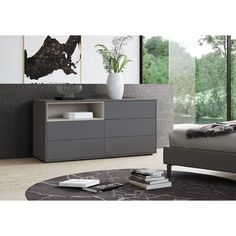 a bed sitting next to a gray dresser in a bedroom on top of a wooden floor