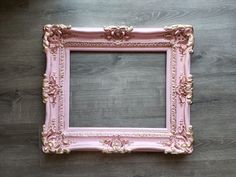 a pink frame with gold trim on a wooden surface