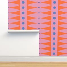 an orange and pink wallpaper with blue dots on it next to a white door