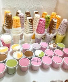 there are many different types of ice creams on the table with each one in their own cup