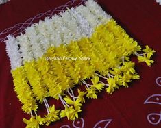 some yellow and white flowers on a red table cloth