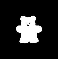 a white teddy bear standing in the dark