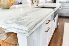 a marble counter top in a kitchen with white cabinets