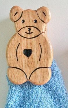 a wooden teddy bear sitting on top of a blue towel