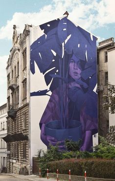 a large mural on the side of a building with a woman holding a flower pot