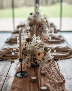 the table is set with candles, flowers and napkins for an elegant centerpiece