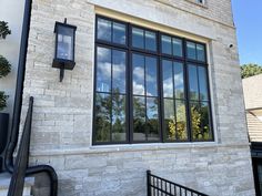 a brick building with several windows on the front and side, along with a black gate