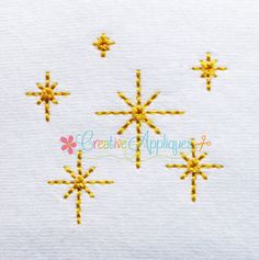 cross stitched snowflakes on white fabric with yellow thread in the shape of stars