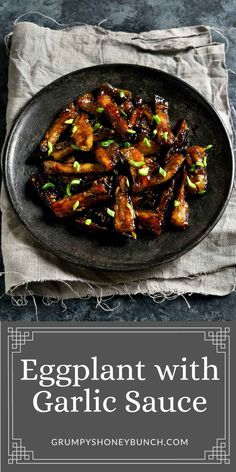 eggplant with garlic sauce in a black plate on top of a gray napkin