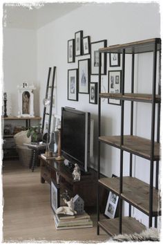 a living room filled with lots of furniture and pictures on the wall next to a flat screen tv