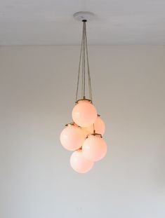 a chandelier hanging from the ceiling in a room with white walls and flooring