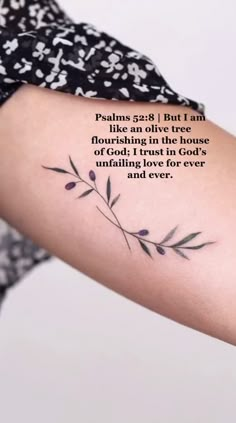 a woman's arm with a quote from the bible on it and an olive branch