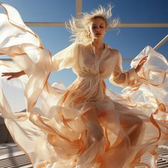 a woman in a flowing dress poses for the camera