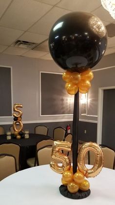 a table topped with balloons in the shape of numbers and an air ballon on top of it