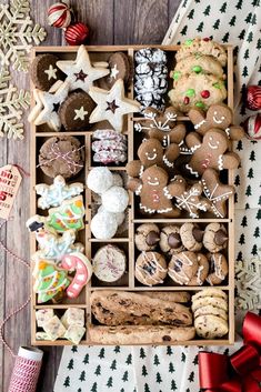 a wooden box filled with lots of different types of cookies and other holiday treats on top of a table