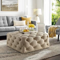 a living room filled with furniture and a coffee table on top of a rug in front of a window