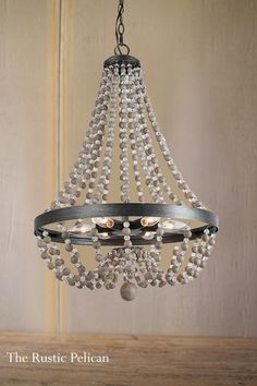 the rustic pelican chandelier is made from metal and features pearls hanging from it