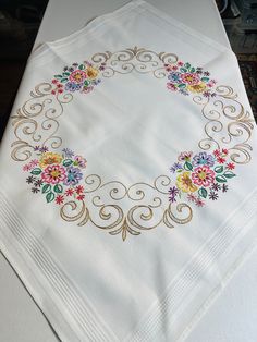 a white table cloth with colorful flowers on it