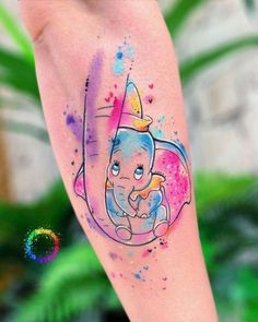 a watercolor tattoo with an elephant on the leg