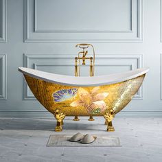 an ornate bathtub is adorned with mosaic tiles and gold leaf accents, along with a mouse