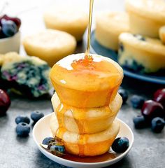 blueberry cheesecakes stacked on top of each other with syrup drizzled over them