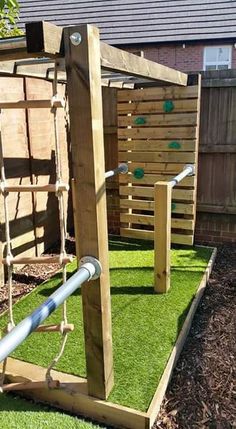 an outdoor play area with artificial grass and wooden structures in the back yard, including a swing set