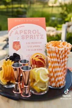 an assortment of different types of drinks on a tray with a sign in the background