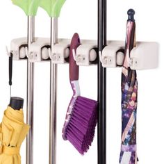 several umbrellas and cleaning brushes hanging on a rack