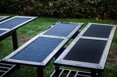 three tables with solar panels on them sitting in the grass