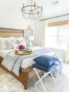 a bedroom with a large bed and a chandelier hanging from it's ceiling