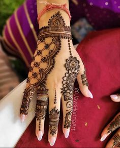 a woman's hand with henna tattoos on it