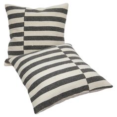 two black and white striped pillows sitting next to each other