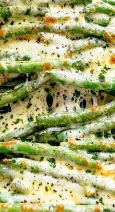 asparagus covered in cheese and parmesan on a baking sheet with a spatula